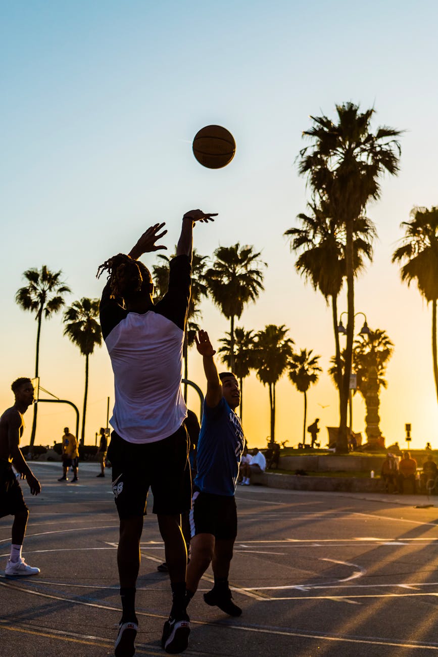 man shooting basketball into the basketball hoop